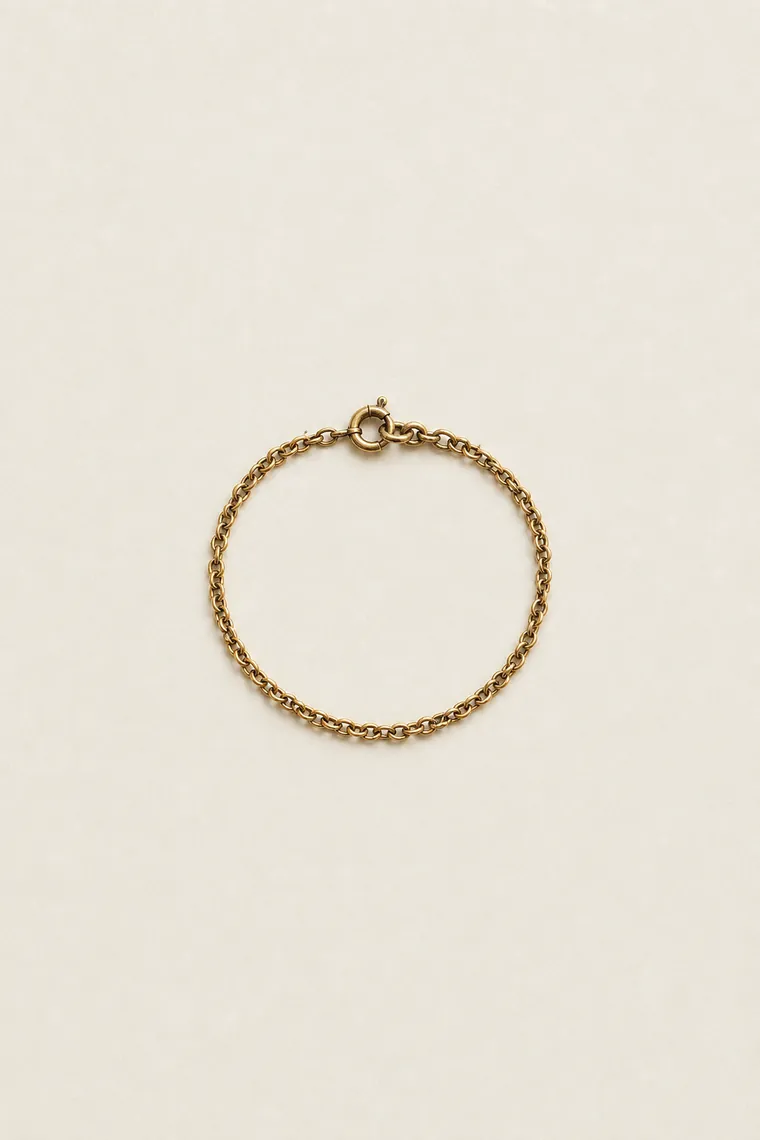 Pulsera fina de cadena de oro viejo enrollada en un círculo pequeño.